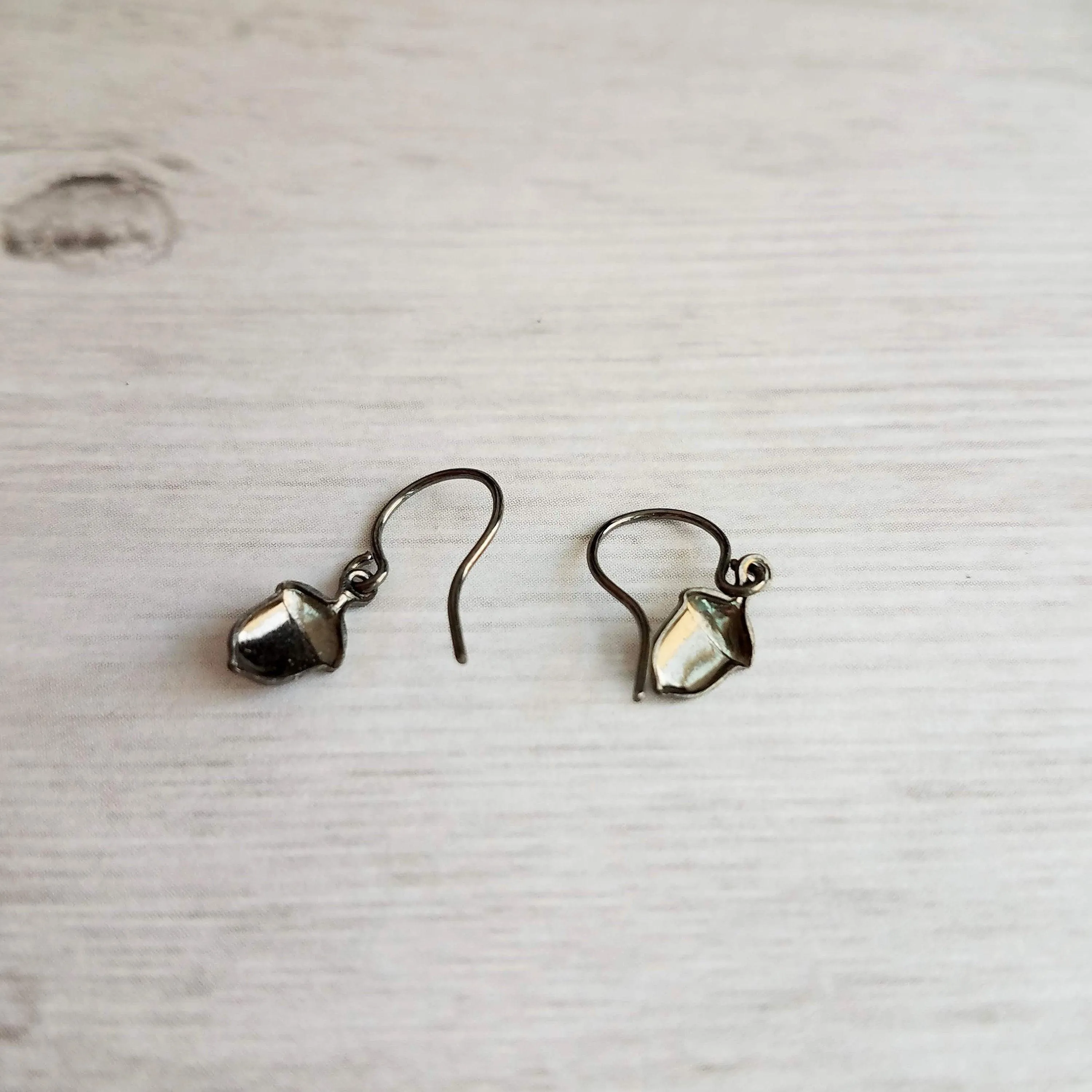 Mini Acorn Earrings - small black silver gunmetal squirrel nut charms dangle on delicate shiny little ear hooks, fall autumn jewelry