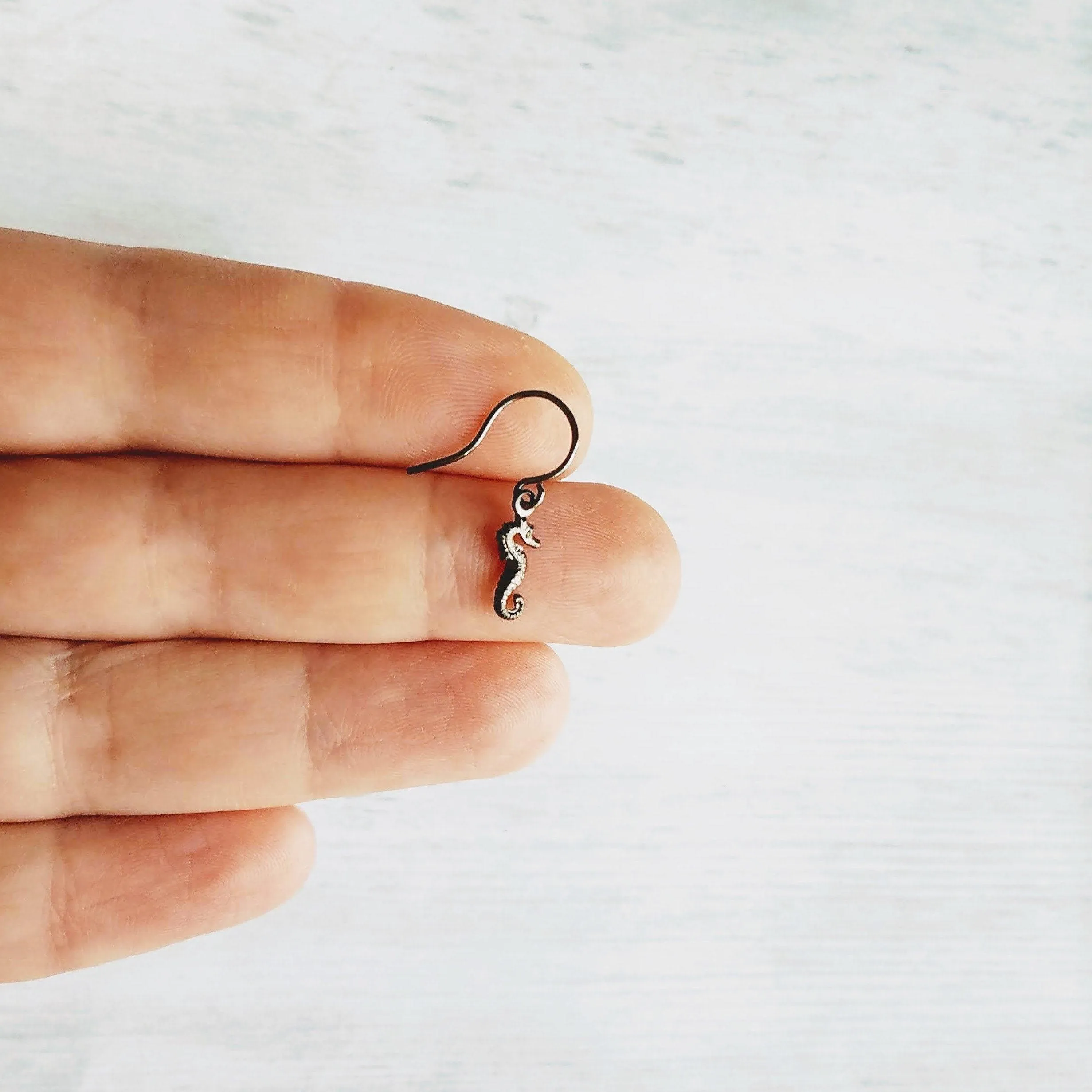 Seahorse Earrings - little tiny black gunmetal silver charms dangle on small simple shiny delicate hooks, minimalist tropical beach memento
