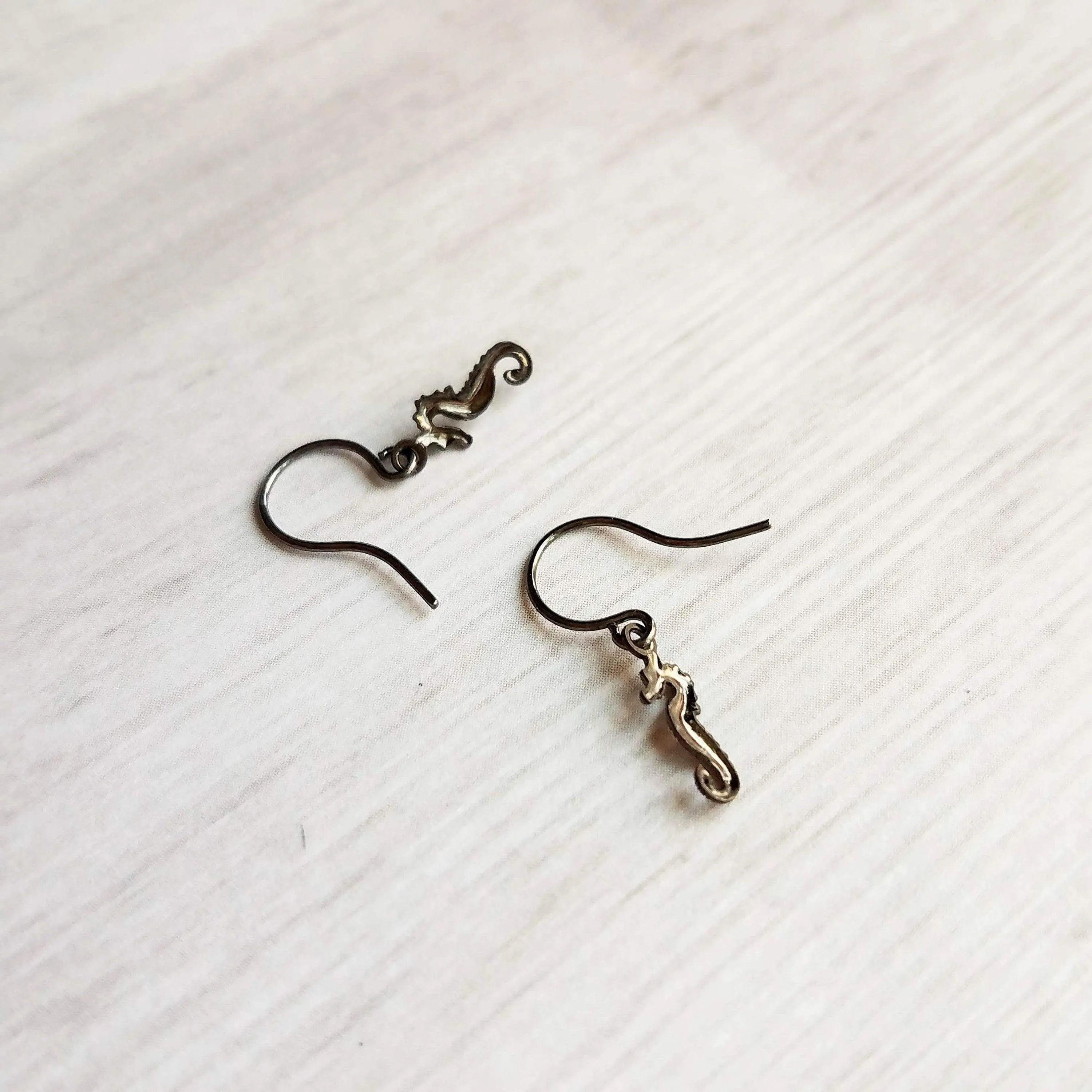 Seahorse Earrings - little tiny black gunmetal silver charms dangle on small simple shiny delicate hooks, minimalist tropical beach memento