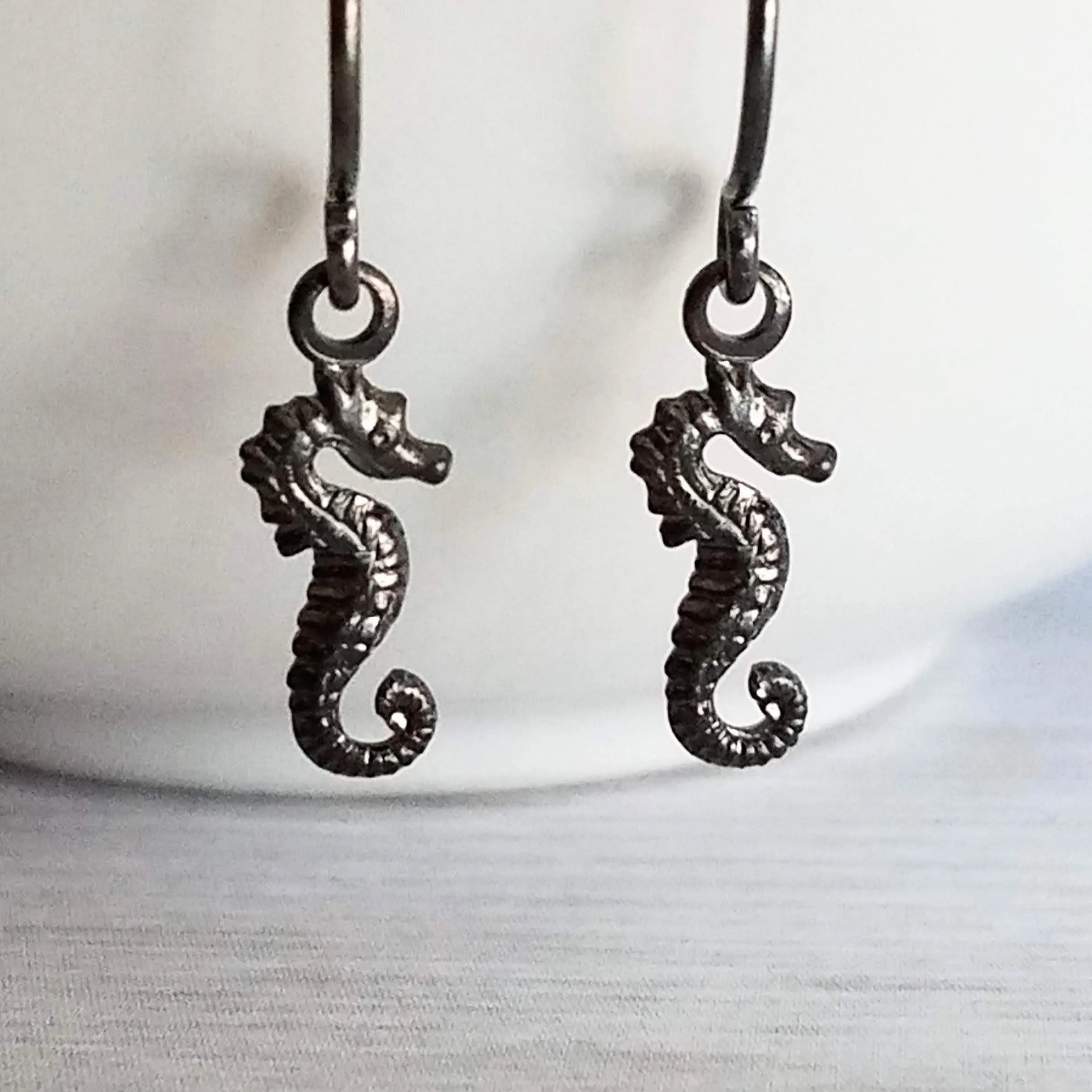 Seahorse Earrings - little tiny black gunmetal silver charms dangle on small simple shiny delicate hooks, minimalist tropical beach memento